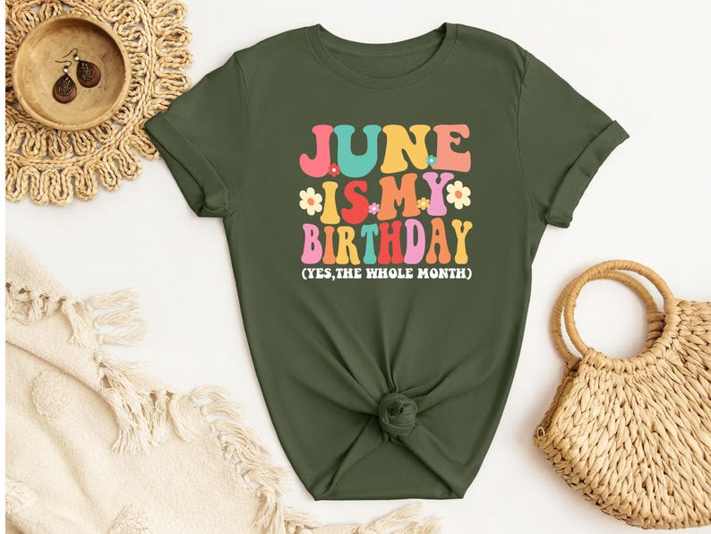 May include: A green t-shirt with the text "JUNE IS MY BIRTHDAY (YES, THE WHOLE MONTH)" in colorful retro lettering with flowers.