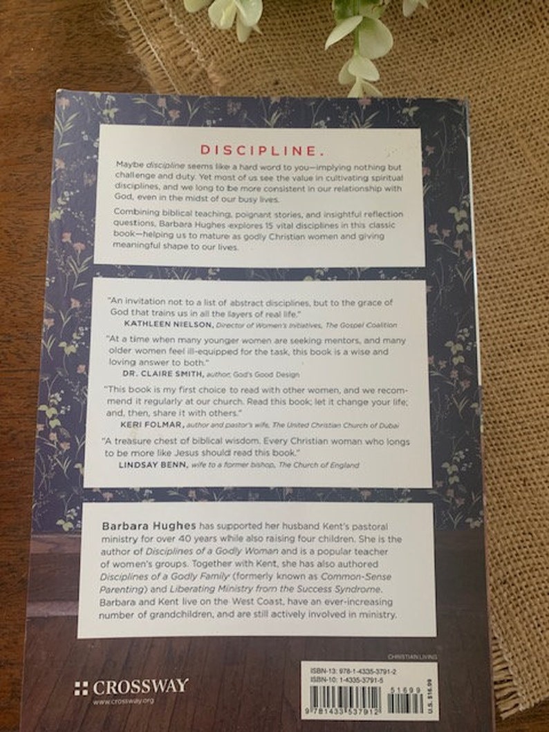 May include: Book cover with a blue background and white flowers. The title of the book is "Discipline" in red letters. The author is Barbara Hughes. The book is about spiritual disciplines for women.