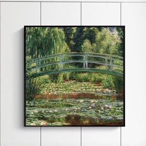 May include: A painting of a green bridge over a pond with water lilies. The bridge is made of wood and has a white railing. The pond is surrounded by trees and bushes. The painting is in a black frame.
