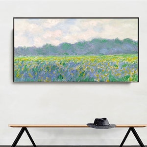 May include: A framed painting depicting a landscape with a field of yellow and blue flowers in the foreground, a line of green trees in the middle ground, and a cloudy sky in the background.