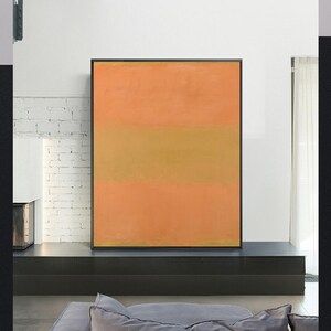 Op de afbeelding: Abstract schilderij met drie horizontale kleurbanden. De bovenste band is lichtoranje, de middelste band is gedempt geelbruin en de onderste band is donkerder oranje. Het schilderij is omlijst in zwart.