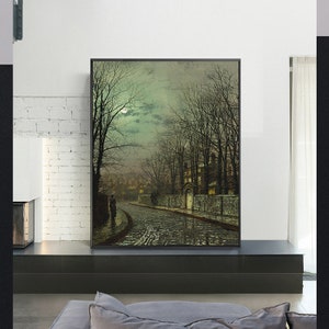 May include: A painting depicting a moonlit street scene with a couple walking in the distance. The street is cobbled and the buildings are lit by street lamps. The sky is a dark blue with a few clouds. The painting is framed in black.