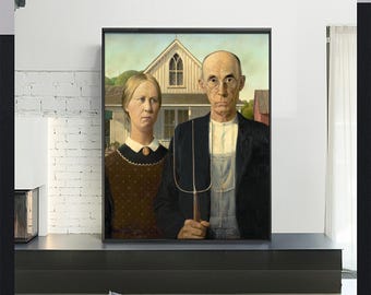 May include: Framed print of the iconic American Gothic painting. The artwork depicts a man and woman standing in front of a house, the man holding a pitchfork. The painting is in a black frame and displayed on a black shelf.