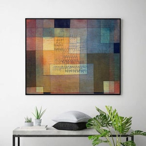 Op de afbeelding: Abstract schilderij met geometrische vormen in tinten van bruin, geel, blauw en groen. Het schilderij heeft een centraal motief van een stadsbeeld met gebouwen en torens.