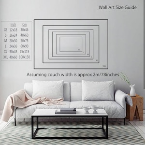 May include: A guide to wall art sizes, showing different sizes of framed artwork on a wall above a white couch. The sizes are listed in inches and centimeters. The text "Assuming couch width is approx 2m/78inches" is also included.