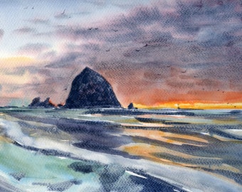 May include: Watercolor painting of a coastal scene at sunset. The artwork depicts a large, dark rock formation in the ocean, with a beach in the foreground. The sky is filled with shades of orange, purple, and gray, with birds flying overhead.