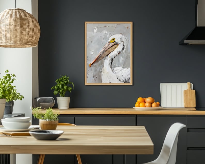 Pode incluir: Uma pintura a &oacute;leo emoldurada de um pelicano branco com um bico longo e um olho amarelo, feita com pinceladas grossas e vis&iacute;veis em tons de branco, cinza e creme, sobre um fundo neutro dentro de uma moldura de madeira clara.