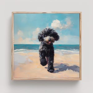May include: A square framed oil painting depicting a fluffy black dog with a white muzzle running on a sandy beach. The background features a calm blue ocean under a bright sky with soft white clouds. The artwork is encased in a light wood frame.