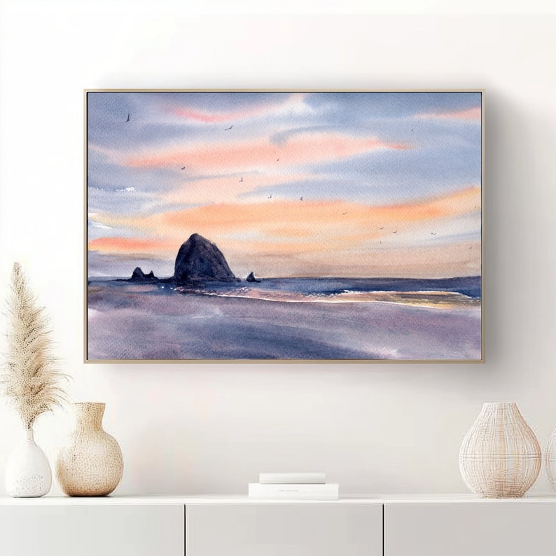 Puede incluir: Una pintura de acuarela de una isla rocosa en el oc&eacute;ano al atardecer. El cielo es de un rosa y naranja suave, y el agua es de un azul profundo. Hay algunas aves volando en el cielo.