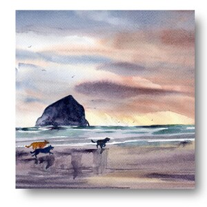 May include: Watercolor painting of a beach scene with a large rock formation in the distance and three dogs running on the sand. The sky is a soft pink and orange with clouds.