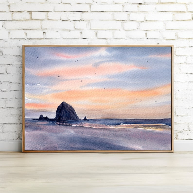 Puede incluir: Pintura acuarela de una isla rocosa en el oc&eacute;ano al atardecer. El cielo es una mezcla de rosa, naranja y azul con algunas aves volando por encima. El agua es de un azul claro con una playa de arena en primer plano.
