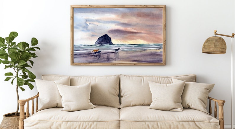 May include: A watercolor painting of a beach scene with a rocky island in the distance. The sky is a soft pink and orange, and the water is a light blue. Three dogs are running on the beach.