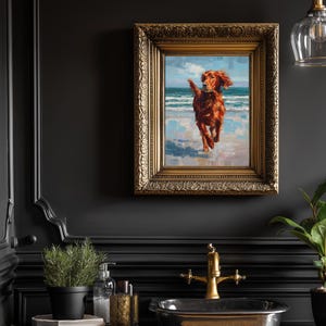 May include: A framed oil painting of a reddish-brown dog running on a beach with blue water and sky. The painting is in a gold ornate frame, mounted on a dark wall. The room also features a black sink, gold faucet, and a potted plant.