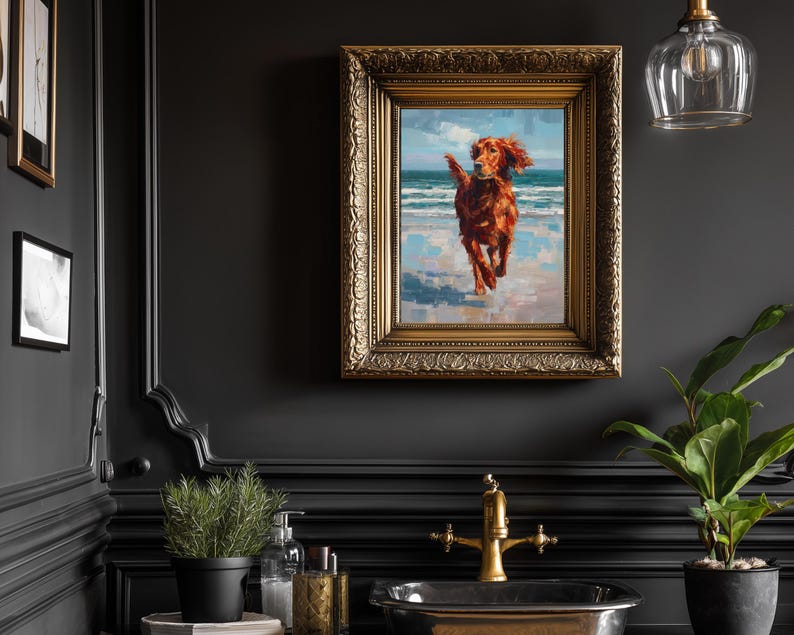 May include: A framed oil painting of a reddish-brown dog running on a beach with blue water and sky. The painting is in a gold ornate frame, mounted on a dark wall. The room also features a black sink, gold faucet, and a potted plant.