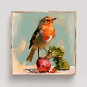 May include: A square framed oil painting depicting a small robin with a bright orange breast perched atop a single red radish with green leafy tops. The bird is rendered with visible brushstrokes against a soft, muted light blue background.