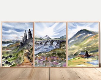 May include: A triptych of watercolor landscape paintings in thin wooden frames. The left panel shows rocky peaks and a dirt path. The center panel depicts a stone bridge over water with purple flowers. The right panel features a small house near a mountain.