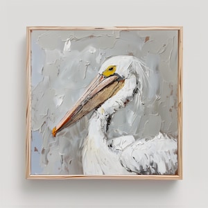 Pode incluir: Uma pintura a &oacute;leo quadrada emoldurada apresentando um pelicano branco com acabamento em empaste texturizado. A ave tem um olho amarelo proeminente e um bico longo de cor bege com detalhes em laranja sobre um fundo cinza neutro.
