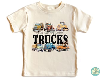 May include: A light beige t-shirt with a graphic of five different trucks. The text "You can never have too many TRUCKS" is printed in black below the trucks.