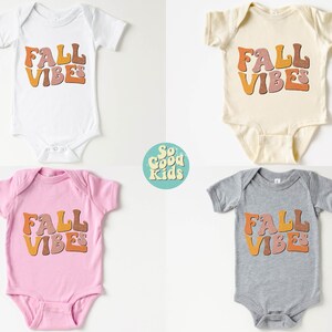 Puede incluir: Cuatro bodies de beb&eacute; en diferentes colores con el texto "FALL VIBES" en una fuente retro. Los bodies son blanco, beige, rosa y gris.