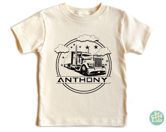 May include: A white t-shirt with a black and white illustration of a semi-truck with the name "ANTHONY" printed on it.