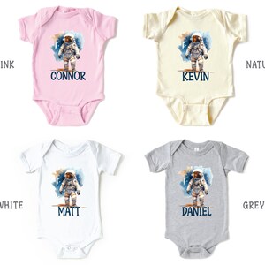May include: Four baby onesies in pink, white, natural, and grey with a watercolor astronaut design and personalized names: Connor, Kevin, Matt, and Daniel.