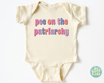 May include: A cream-colored baby onesie with the text "pee on the patriarchy" in colorful, retro-style letters.