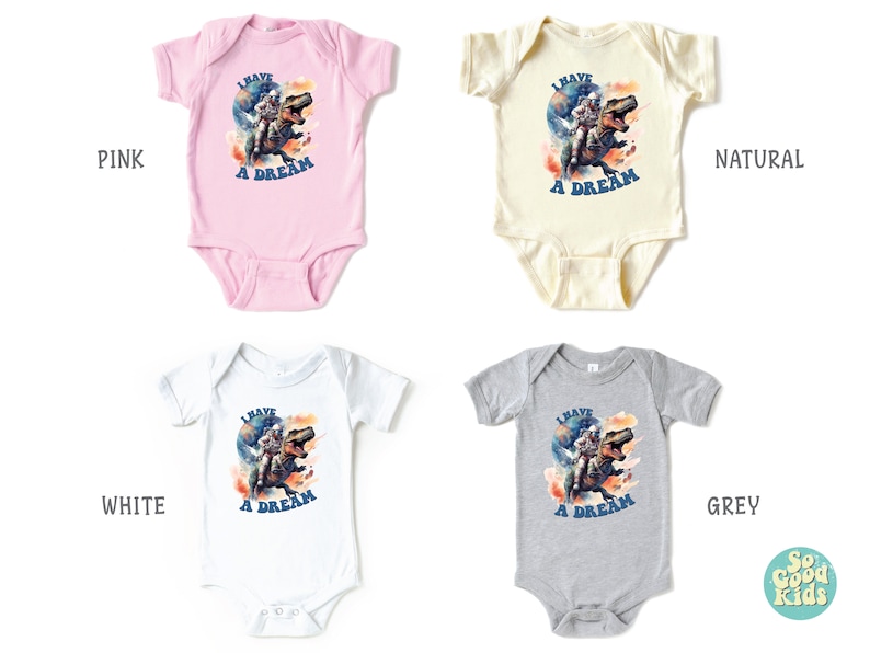 Pode incluir: Quatro bodies de beb&ecirc; em diferentes cores: rosa, natural, branco e cinza. Cada body apresenta um gr&aacute;fico de um astronauta montando um dinossauro com o texto "Eu tenho um sonho".