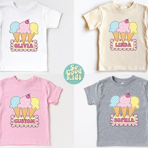 May include: Four toddler t-shirts with a graphic of three ice cream cones with a cherry on top. The shirts are in white, beige, pink, and gray. The shirts have the names Olivia, Linda, Custom, and Sophia printed on them.