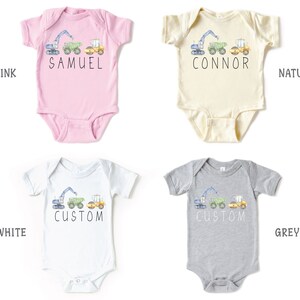 May include: Five baby onesies in different colors, pink, natural, white, grey, and a light blue. Each onesie has a graphic of a construction vehicle with the text "Samuel", "Connor", "Custom", "Custom", and "So Good Kids" on them.