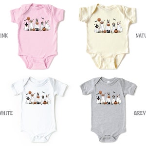 Puede incluir: Cuatro bodies de beb&eacute; en diferentes colores: rosa, blanco, natural y gris. Cada body presenta un gr&aacute;fico de un grupo de perros disfrazados de fantasmas para Halloween. El texto "So Good Kids" es visible en la esquina inferior derecha de la imagen.