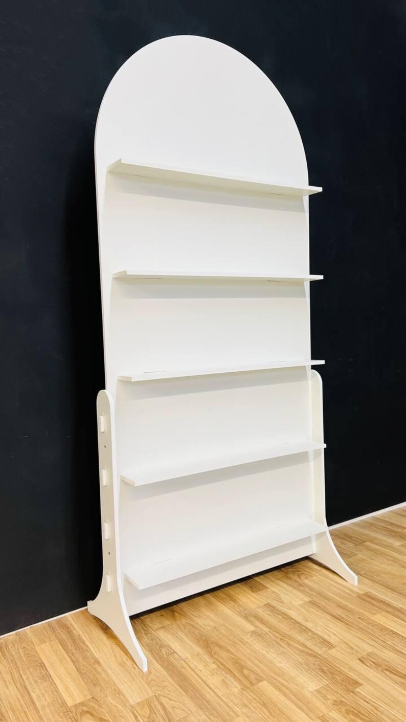 A beautifully designed arched party backdrop featuring built-in shelves, perfect for showcasing decorations, party favors, or other items at events and gatherings. Ideal for creating a stylish and functional display at any celebration.