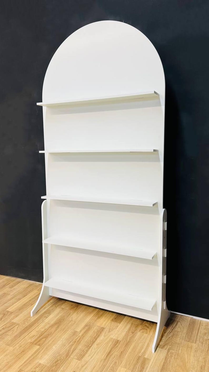 A beautifully designed arched party backdrop featuring built-in shelves, perfect for showcasing decorations, party favors, or other items at events and gatherings. Ideal for creating a stylish and functional display at any celebration.