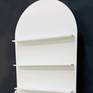 A beautifully designed arched party backdrop featuring built-in shelves, perfect for showcasing decorations, party favors, or other items at events and gatherings. Ideal for creating a stylish and functional display at any celebration.