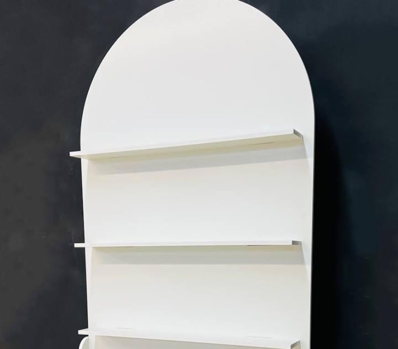 A beautifully designed arched party backdrop featuring built-in shelves, perfect for showcasing decorations, party favors, or other items at events and gatherings. Ideal for creating a stylish and functional display at any celebration.