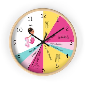 May include: A round wall clock with a light wood frame. The clock face is divided into colorful segments, with a mermaid illustration at the 11 o'clock position. The clock hands are black. The clock face includes the text "Aria", "Lunch", "Nap Time", "Water/Bubbles", "Hair/Ms. Rachel", "Speech", "Reading", and "Bath Time".