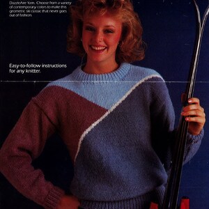 May include: A woman wearing a blue, white and burgundy geometric patterned sweater. She is holding a black ski pole. The text "FREE INSTRUCTIONS with purchase of Caron® Dazzle Aire" is at the top of the image. The text "Easy-to-follow instructions for any knitter." is at the bottom of the image.