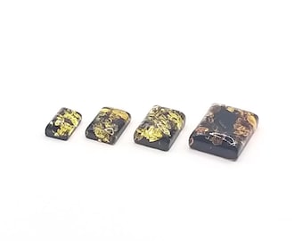 May include: Four rectangular pieces of amber with a black background and yellow and brown inclusions. The pieces are arranged in order of size, with the largest piece on the right and the smallest piece on the left.