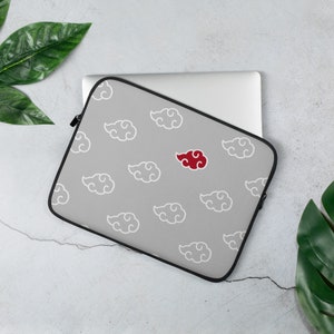 Puede incluir: Funda para portátil gris con un patrón de nubes blancas y una sola nube roja. La funda está hecha de un material suave y duradero y tiene una cremallera.