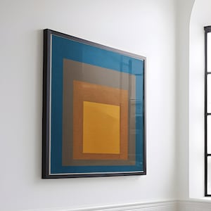 May include: A white tiled bathroom with a black freestanding bathtub, a black faucet, and a towel hanging over the side. A framed abstract painting with blue, brown, and yellow squares hangs on the wall above the tub. A large arched window with frosted glass panes is in the background.