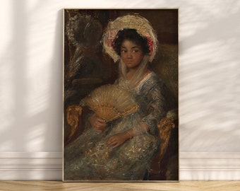 May include: A framed vintage portrait of a person seated in a chair, holding a fan. The person wears a light blue dress and a white hat with pink accents. The portrait is in a gold frame and is displayed on a wooden floor.