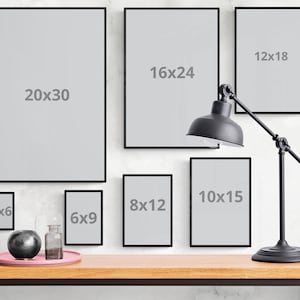 May include: A collection of black picture frames of various sizes hanging on a white wall. The frames are empty and have the dimensions 4x6, 6x9, 8x12, 10x15, 12x18, 16x24, and 20x30 inches.