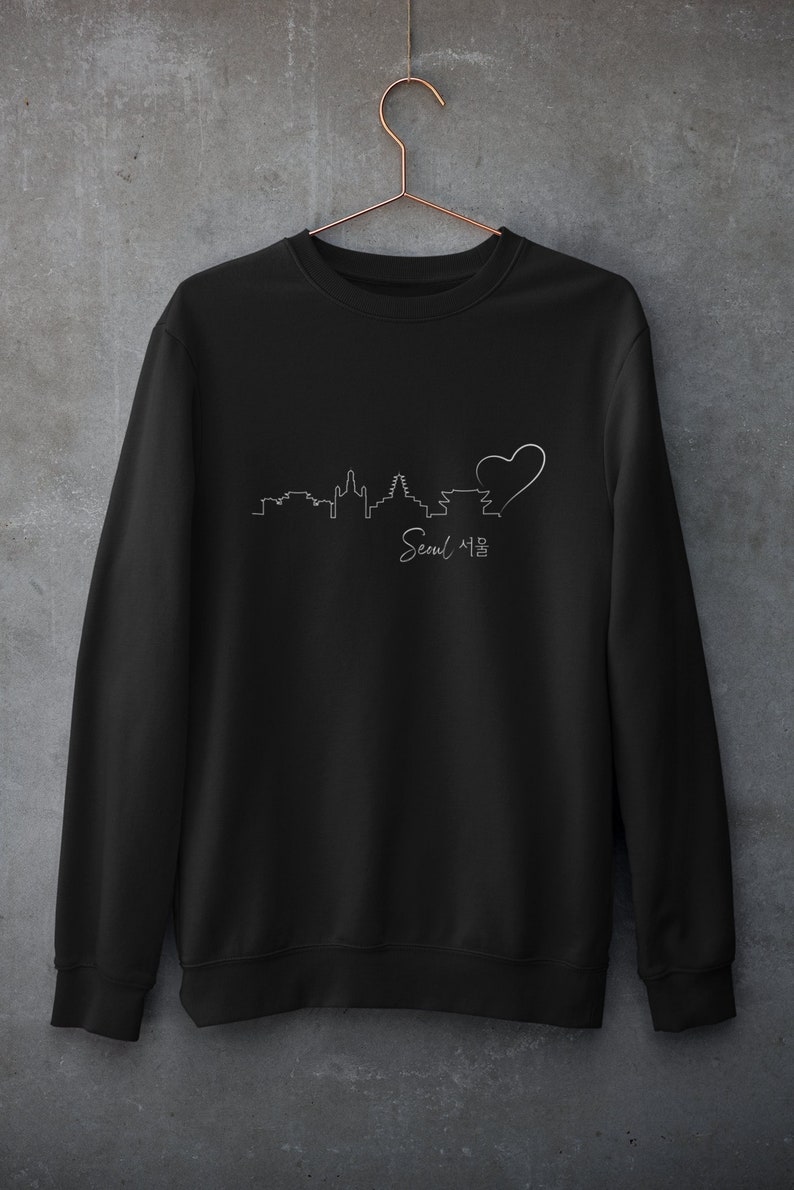 May include: Black sweatshirt with a white outline of the Seoul skyline and a heart, with the text "Seoul 서울" underneath.