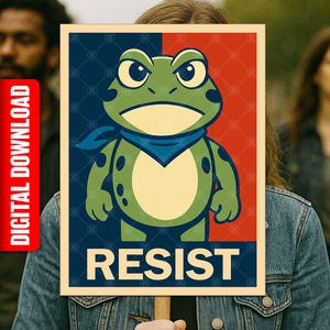 May include: A poster with a cartoon frog wearing a blue bandana, set against a red and blue background. The word "RESIST" is printed at the bottom. The poster is held up by a person.