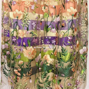 May include: A sheer skirt featuring horizontal stripes in shades of peach, purple, and green, overlaid with intricate floral embroidery in pink, orange, green, and lavender. The text Honor Design ABQ is visible in the center of the fabric.