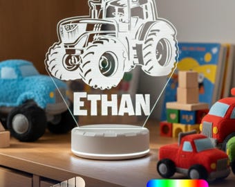 May include: A clear acrylic night light featuring an etched tractor design and the name ETHAN in bold capital letters. The light sits on a round white base and includes a dimmable feature with 16 light colors. A Made in USA badge is visible.