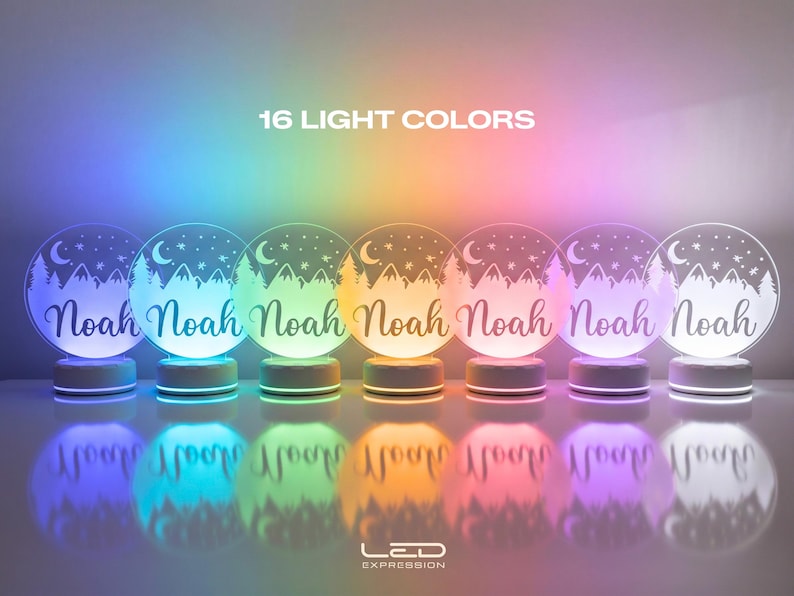 May include: Seven illuminated LED night lights with the name "Noah" in a script font. Each light has a circular design with a mountain and tree scene, a crescent moon, and stars. The text "16 LIGHT COLORS" is at the top.