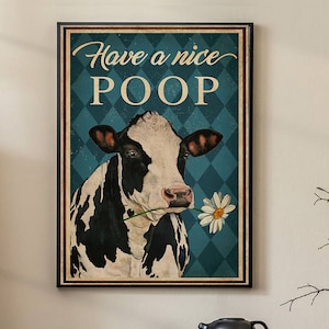 Könnte beinhalten: Ein Vintage-Poster mit einer schwarz-weißen Kuh, die eine Gänseblümchen im Maul hält. Das Poster hat einen blauen Hintergrund mit einem Rautenmuster und den Text "Have a nice POOP".