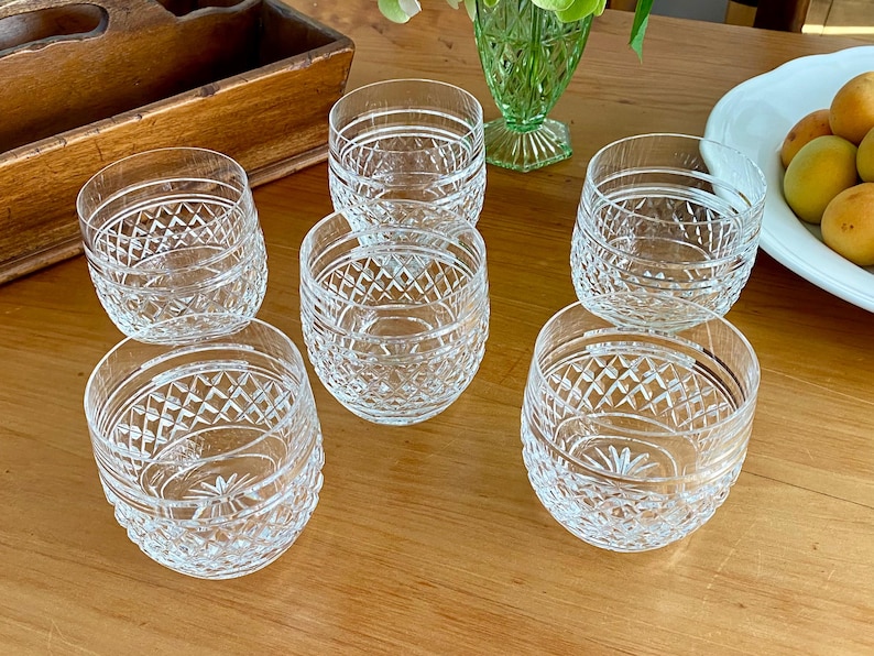 Puede incluir: Seis vasos de cristal tallado transparente con un dise&ntilde;o de diamantes y estrellas. Los vasos est&aacute;n colocados sobre una mesa de madera, mostrando su intrincado dise&ntilde;o. Adecuado para servir bebidas.