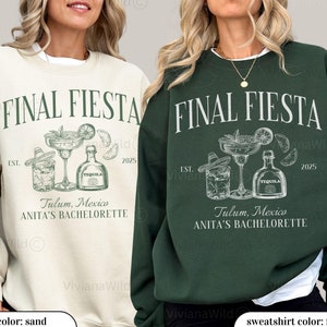 May include: Two sweatshirts with the text "FINAL FIESTA" in white. The design features a margarita glass, a glass of ice, and a bottle of tequila. The text "Tulum, Mexico" and "ANITA'S BACHELORETTE" are also included. The sweatshirt on the left is sand colored with moss green text. The sweatshirt on the right is forest green with white text.