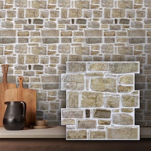 May include: A rectangular wall panel featuring a realistic 3D stone texture with varied shades of beige, tan, and gray. The panel displays an interlocking pattern of rectangular and square stones with white grout lines, mimicking a natural masonry wall.